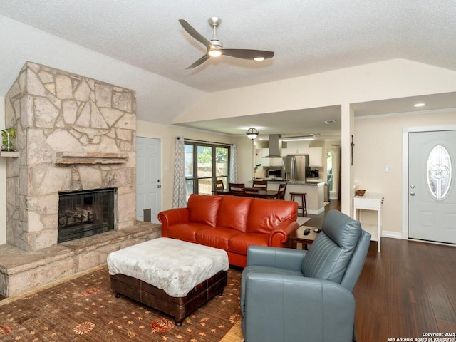 10707 Lake Path, San Antonio, TX 78217 - living room featuring vaulted ceiling, a ceiling fan, wood finished floors, a stone fireplace, and a textured ceiling