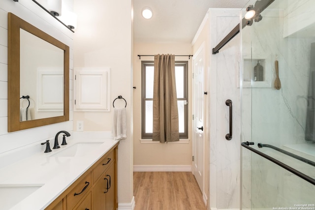 10707 Lake Path, San Antonio, TX 78217 - bathroom with double vanity, a marble finish shower, and wood finished floors