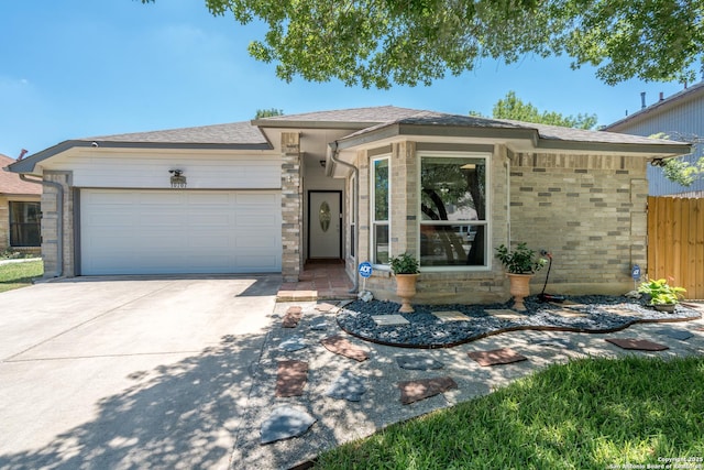 10707 Lake Path, San Antonio, TX 78217 - view of front of home with an attached garage, concrete driveway, and stone siding