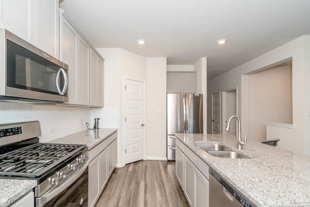 4951 Ranahan Pass, Saint Hedwig, TX 78152 - kitchen featuring stainless steel appliances, light wood-style flooring, tasteful backsplash, light stone countertops, and recessed lighting