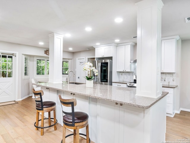 132 Wagon Trail Rd, Shavano Park, TX 78231 - kitchen featuring decorative columns, stainless steel fridge with ice dispenser, light wood-style floors, decorative backsplash, and recessed lighting