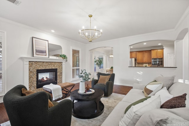 20907 Cactus Peak, San Antonio, TX 78258 - living area featuring arched walkways, a chandelier, wood finished floors, ornamental molding, and a fireplace