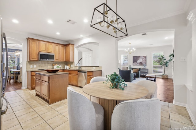 20907 Cactus Peak, San Antonio, TX 78258 - kitchen featuring stainless steel appliances, arched walkways, a chandelier, a kitchen island, and tasteful backsplash