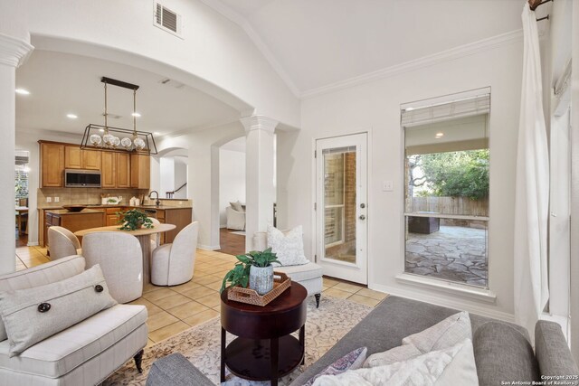 20907 Cactus Peak, San Antonio, TX 78258 - living room featuring ornate columns, light tile patterned flooring, arched walkways, ornamental molding, and vaulted ceiling