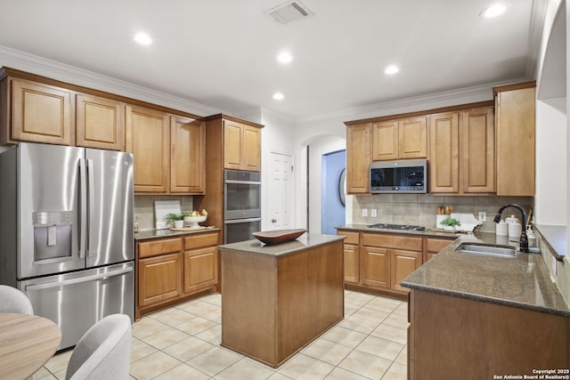 20907 Cactus Peak, San Antonio, TX 78258 - kitchen with appliances with stainless steel finishes, arched walkways, backsplash, dark stone counters, and ornamental molding