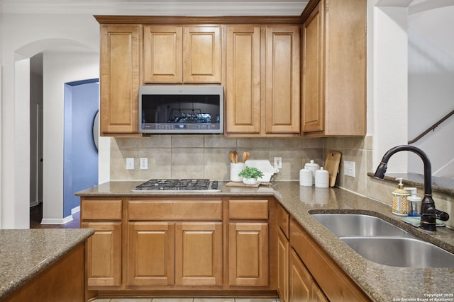 20907 Cactus Peak, San Antonio, TX 78258 - kitchen featuring stainless steel appliances, tasteful backsplash, dark stone countertops, brown cabinetry, and crown molding
