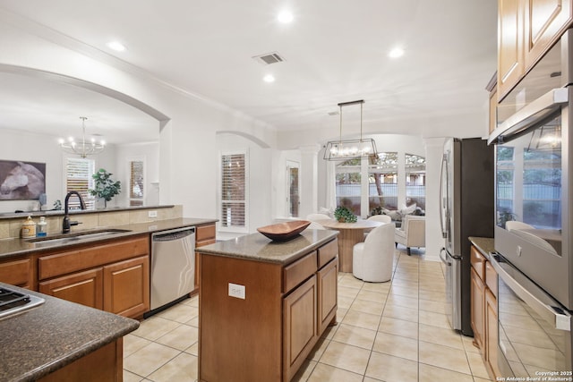 20907 Cactus Peak, San Antonio, TX 78258 - kitchen with stainless steel appliances, a chandelier, light tile patterned floors, healthy amount of natural light, and crown molding