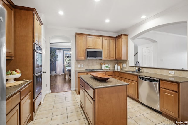 20907 Cactus Peak, San Antonio, TX 78258 - kitchen featuring appliances with stainless steel finishes, arched walkways, light tile patterned floors, a center island, and ornamental molding