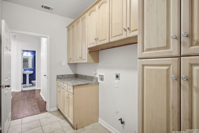 20907 Cactus Peak, San Antonio, TX 78258 - washroom featuring electric dryer hookup, cabinet space, washer hookup, and light tile patterned flooring