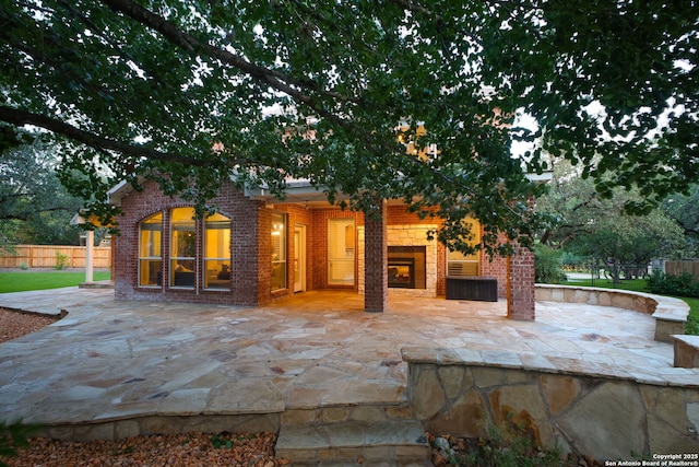 20907 Cactus Peak, San Antonio, TX 78258 - rear view of property featuring a fireplace, brick siding, and a patio area