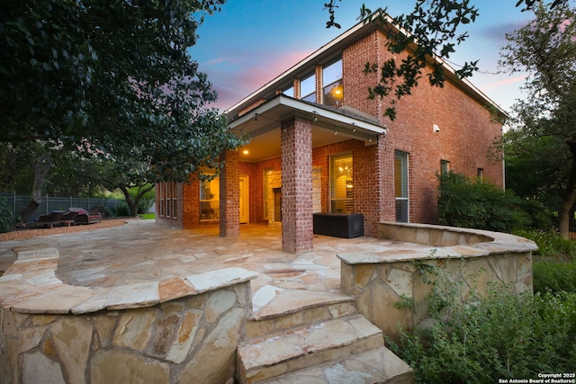 20907 Cactus Peak, San Antonio, TX 78258 - back of property at dusk with brick siding and a patio