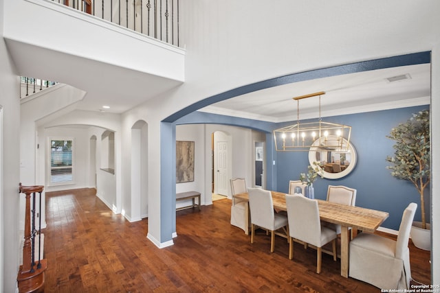 20907 Cactus Peak, San Antonio, TX 78258 - dining area featuring arched walkways, dark wood-type flooring, crown molding, a chandelier, and a high ceiling