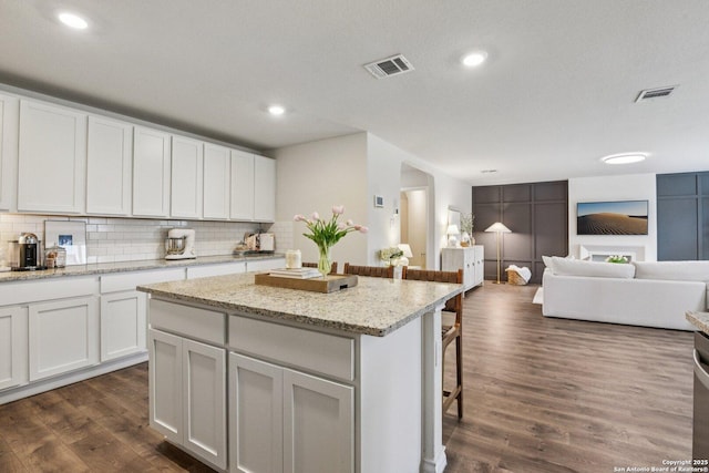 183 Amethyst Woodstar, San Antonio, TX 78253 - kitchen featuring a kitchen bar, a kitchen island, decorative backsplash, dark wood-style floors, and recessed lighting