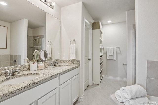 183 Amethyst Woodstar, San Antonio, TX 78253 - full bathroom featuring double vanity, a tile shower, a spacious closet, and recessed lighting