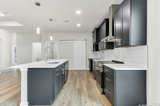 9911 Loma Alta Cir, Converse, TX 78109 - kitchen with appliances with stainless steel finishes, a barn door, light wood-style floors, light countertops, and recessed lighting