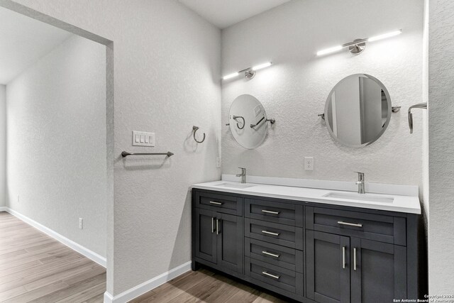 9911 Loma Alta Cir, Converse, TX 78109 - full bath featuring wood finished floors, double vanity, and a textured wall