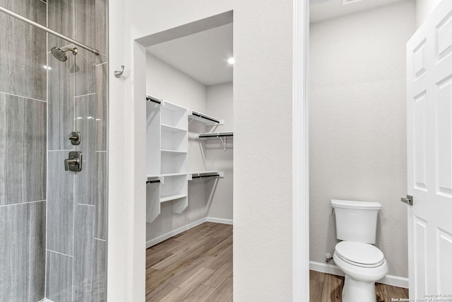 9911 Loma Alta Cir, Converse, TX 78109 - full bathroom featuring a walk in closet, a tile shower, and wood finished floors
