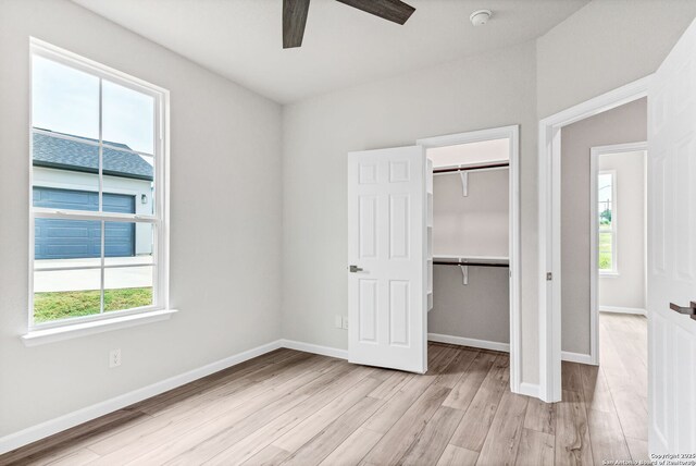 9911 Loma Alta Cir, Converse, TX 78109 - unfurnished bedroom with light wood-style floors, a closet, ceiling fan, and a spacious closet