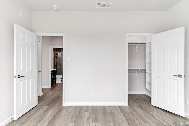 9911 Loma Alta Cir, Converse, TX 78109 - unfurnished bedroom featuring wood finished floors, a closet, and a walk in closet