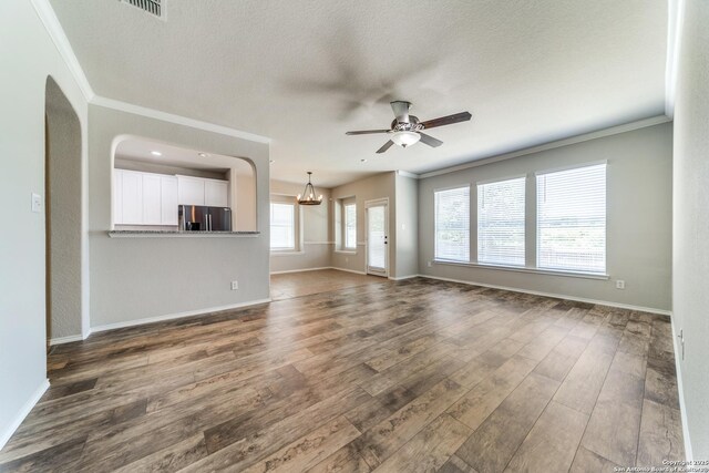 26215 Presidio Blf, Boerne, TX 78015 - unfurnished living room featuring ornamental molding, a ceiling fan, dark wood-style floors, a textured ceiling, and a chandelier