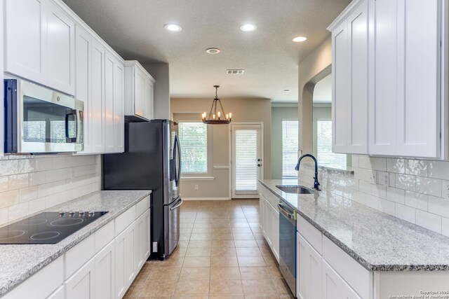 26215 Presidio Blf, Boerne, TX 78015 - kitchen with appliances with stainless steel finishes, white cabinetry, recessed lighting, light tile patterned flooring, and tasteful backsplash
