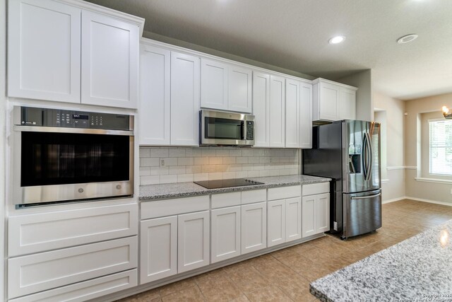 26215 Presidio Blf, Boerne, TX 78015 - kitchen with appliances with stainless steel finishes, backsplash, white cabinetry, recessed lighting, and light tile patterned floors
