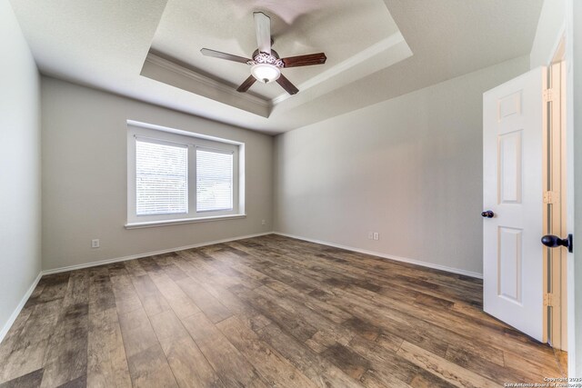 26215 Presidio Blf, Boerne, TX 78015 - unfurnished room with a raised ceiling, ornamental molding, a ceiling fan, and dark wood-style flooring