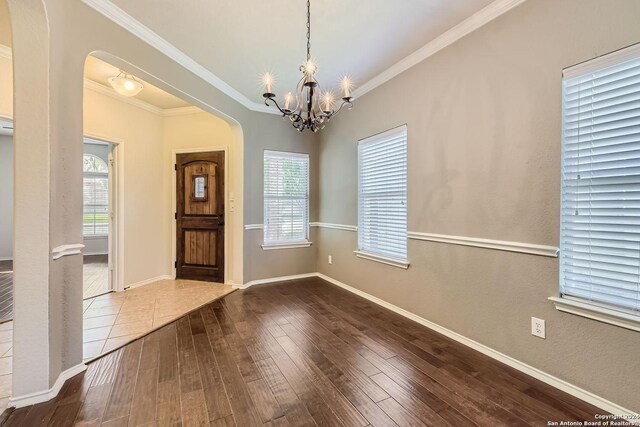 26215 Presidio Blf, Boerne, TX 78015 - unfurnished dining area with arched walkways, a chandelier, hardwood / wood-style floors, plenty of natural light, and ornamental molding