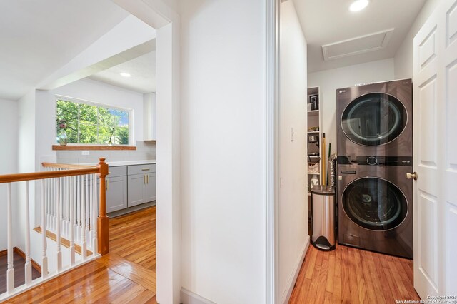 227 Devonshire, San Antonio, TX 78209 - washroom featuring stacked washer and clothes dryer, light wood-type flooring, attic access, and recessed lighting