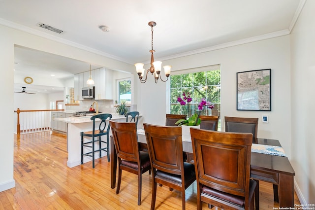 227 Devonshire, San Antonio, TX 78209 - dining space featuring a chandelier, light wood-type flooring, crown molding, and ceiling fan