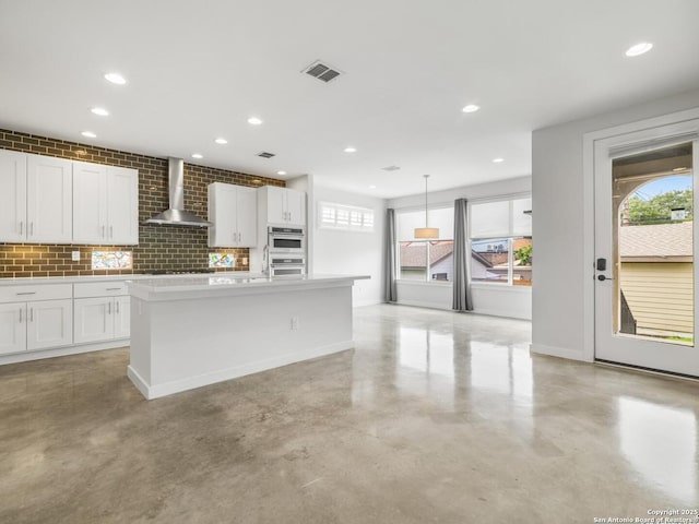 338 E Olmos, San Antonio, TX 78212 - kitchen with wall chimney range hood, finished concrete floors, plenty of natural light, white cabinets, and recessed lighting