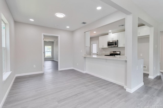 2738 Ravina, San Antonio, TX 78222 - kitchen with stainless steel appliances, white cabinetry, light wood-type flooring, recessed lighting, and light stone counters