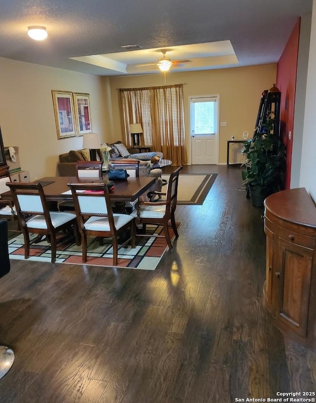 15923 Silver Rose, Selma, TX 78154 - dining room with dark wood-style floors, a tray ceiling, and a ceiling fan