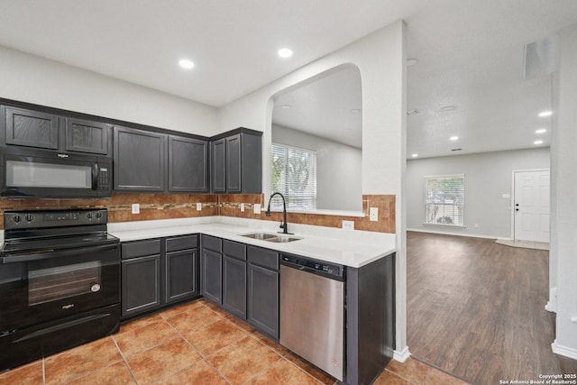 12107 Dawson Cir, San Antonio, TX 78253 - kitchen with black appliances, backsplash, light countertops, recessed lighting, and arched walkways