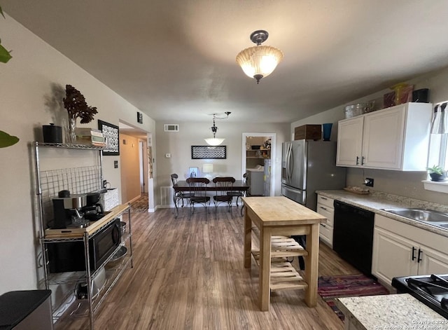 123 Turkey Dr, Harper, TX 78631 - kitchen featuring black dishwasher, stainless steel fridge, white cabinets, and dark wood-type flooring