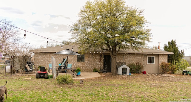 123 Turkey Dr, Harper, TX 78631 - back of property featuring a patio area, a lawn, and brick siding