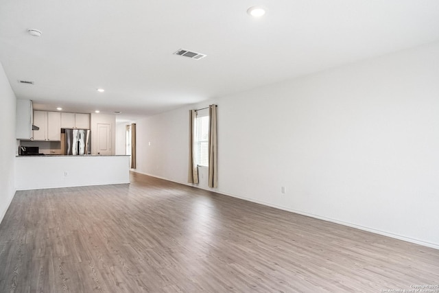 7002 Satellite, San Antonio, TX 78252 - unfurnished living room featuring wood finished floors and recessed lighting
