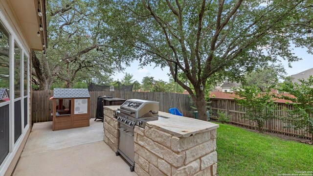 21810 Thunder Basin, San Antonio, TX 78261 - fenced backyard with exterior kitchen and a patio area