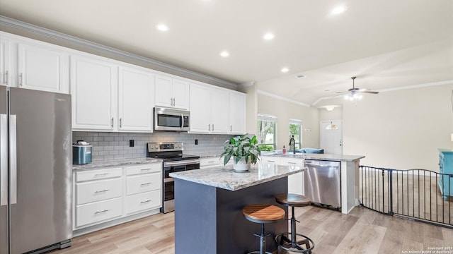 21810 Thunder Basin, San Antonio, TX 78261 - kitchen featuring appliances with stainless steel finishes, a peninsula, light wood-style floors, crown molding, and a center island