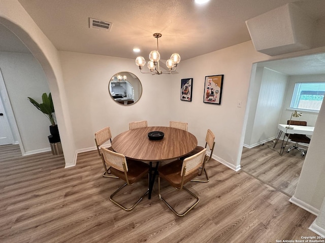 414 Clower, San Antonio, TX 78212 - dining room featuring arched walkways, wood finished floors, and a chandelier