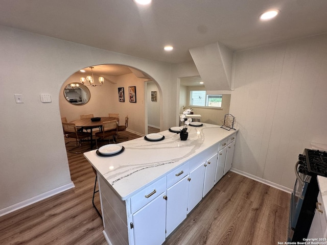 414 Clower, San Antonio, TX 78212 - kitchen with black gas range, arched walkways, dark wood-type flooring, a peninsula, and a chandelier