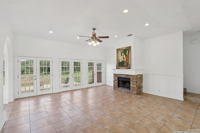 23613 Grayling Ln, San Antonio, TX 78259 - unfurnished living room featuring french doors, recessed lighting, a ceiling fan, a fireplace, and arched walkways