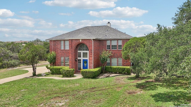 23613 Grayling Ln, San Antonio, TX 78259 - view of front of home featuring brick siding, a front lawn, a chimney, and a shingled roof