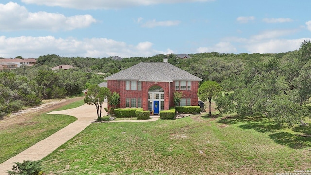 23613 Grayling Ln, San Antonio, TX 78259 - view of front of house featuring brick siding, a front lawn, driveway, and a chimney