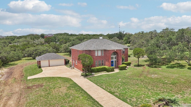 23613 Grayling Ln, San Antonio, TX 78259 - view of front of house featuring a garage, an outbuilding, a front yard, brick siding, and a chimney