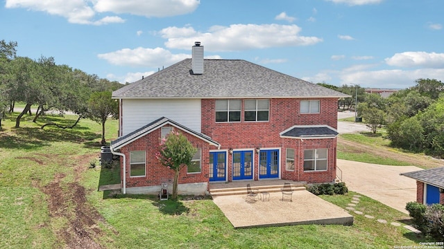 23613 Grayling Ln, San Antonio, TX 78259 - rear view of house featuring a chimney, brick siding, a yard, a patio, and driveway