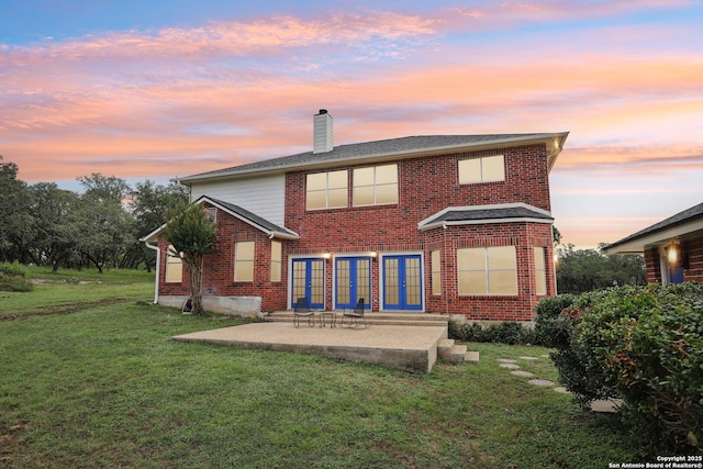 23613 Grayling Ln, San Antonio, TX 78259 - rear view of house featuring brick siding, a chimney, french doors, and a lawn