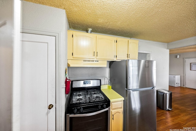 702 John Adams, San Antonio, TX 78228 - kitchen with appliances with stainless steel finishes, under cabinet range hood, a textured ceiling, dark wood-style floors, and light countertops