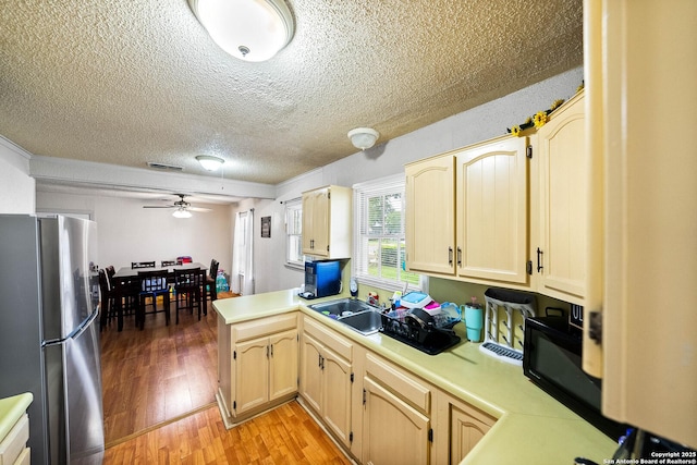 702 John Adams, San Antonio, TX 78228 - kitchen featuring freestanding refrigerator, light countertops, a textured ceiling, a ceiling fan, and light wood-style floors