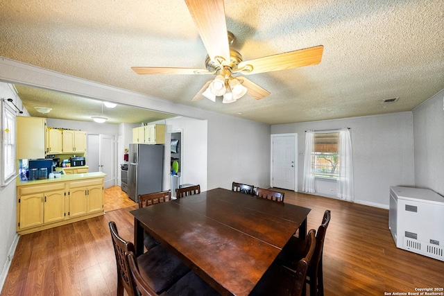 702 John Adams, San Antonio, TX 78228 - dining room featuring a textured ceiling, heating unit, wood finished floors, and ceiling fan